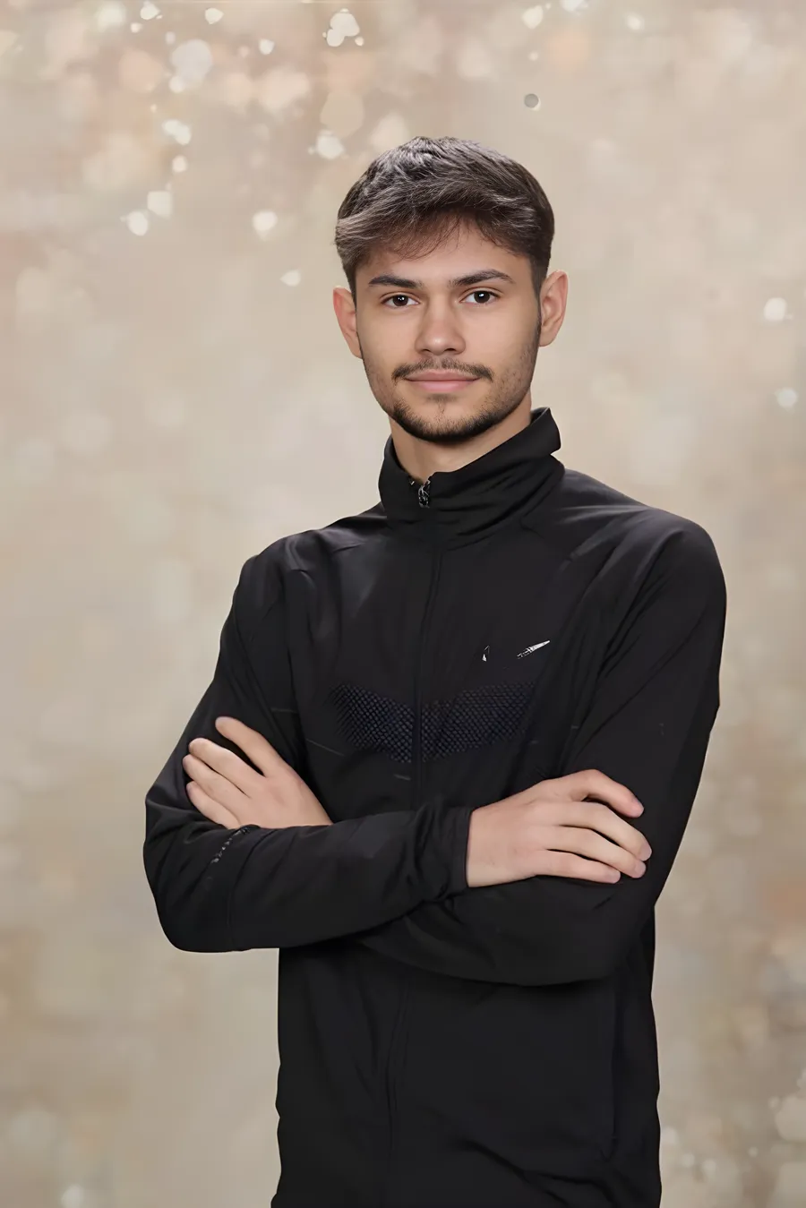 Leotrim Thaqi standing with arms crossed